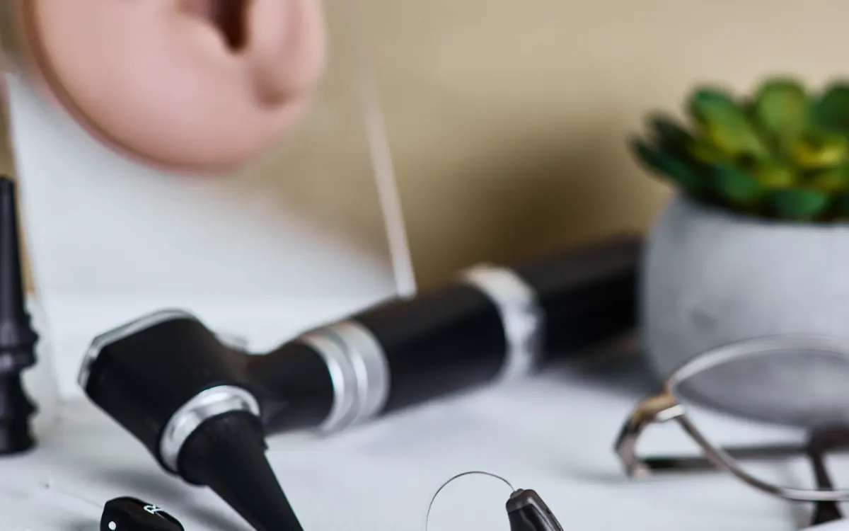 Otoscópio e aparelhos auditivos sobre a mesa do consultório